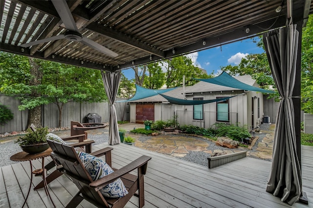 wooden deck featuring ceiling fan, a fenced backyard, a pergola, and an outdoor fire pit