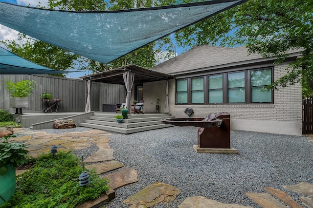 back of property with a deck, a patio, fence, and brick siding