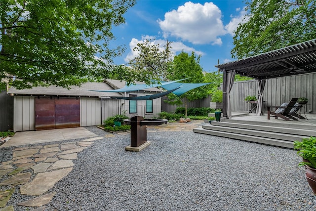 view of yard featuring a patio area, a wooden deck, a pergola, and fence