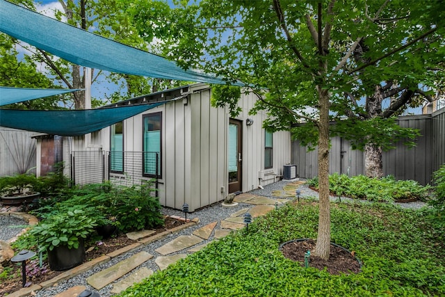 view of outdoor structure with cooling unit and fence