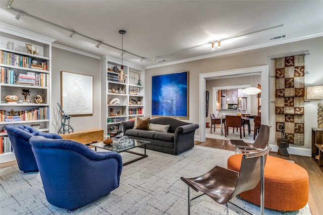 living room featuring crown molding, wood finished floors, visible vents, and track lighting