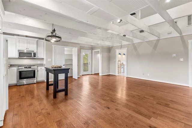 kitchen featuring baseboards, light wood-style floors, open floor plan, and stainless steel appliances