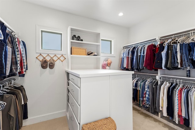 walk in closet with light carpet