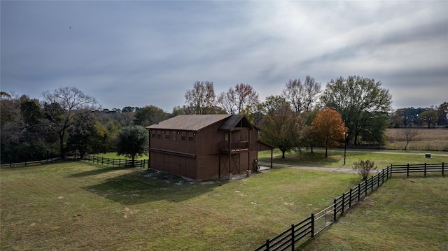 view of outbuilding with a rural view and fence