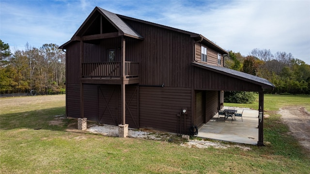 view of home's exterior with a yard, fence, an outbuilding, and a shingled roof