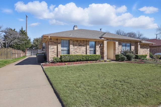 view of front of house with driveway, fence, cooling unit, a front yard, and brick siding