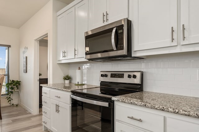 kitchen with tasteful backsplash, white cabinetry, and stainless steel appliances