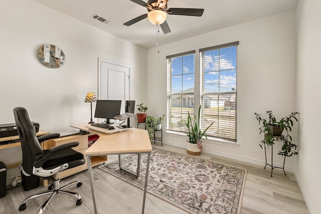 office area with visible vents, baseboards, a ceiling fan, and light wood finished floors