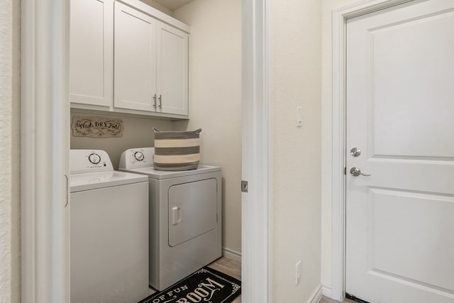 clothes washing area featuring cabinet space and separate washer and dryer