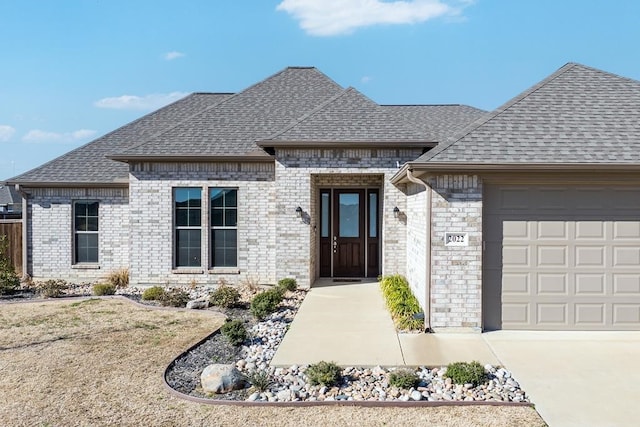 2022 Clay St, Mabank, TX 75147 - view of front facade with concrete driveway, brick siding, a shingled roof, and a garage