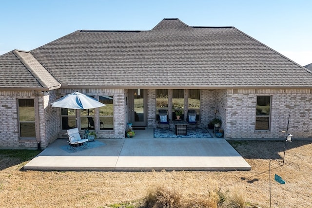 back of property featuring a patio area, brick siding, and a shingled roof