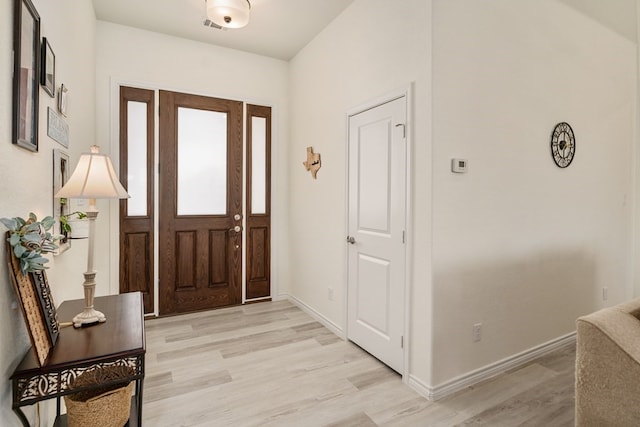 entryway with light wood finished floors and baseboards