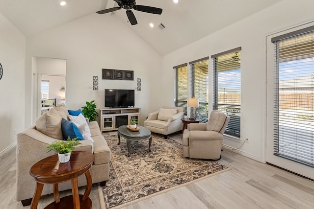 living area featuring visible vents, high vaulted ceiling, wood finished floors, baseboards, and ceiling fan