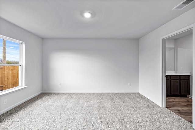 spare room featuring visible vents, baseboards, and carpet flooring