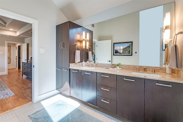 bathroom with double vanity, baseboards, and a sink