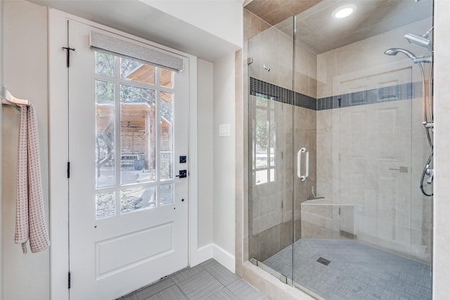 bathroom featuring baseboards and a stall shower