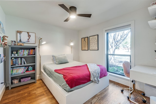 bedroom featuring baseboards, a ceiling fan, and wood finished floors