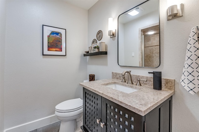 bathroom featuring baseboards, toilet, and vanity