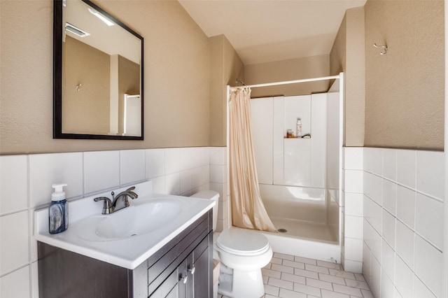 bathroom featuring tile walls, a stall shower, vanity, and tile patterned flooring