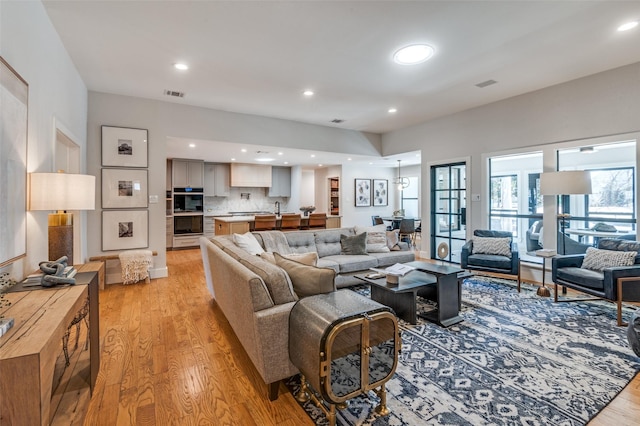 living area featuring recessed lighting, visible vents, and light wood-style flooring