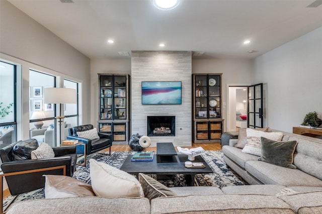 living room with recessed lighting, wood finished floors, and a tile fireplace