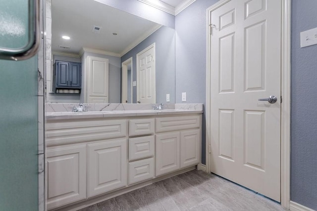 full bathroom featuring a sink, visible vents, double vanity, and crown molding