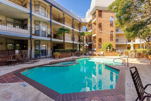 view of swimming pool featuring a pool with connected hot tub and a patio