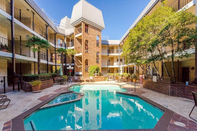 view of pool with a patio area and a pool with connected hot tub