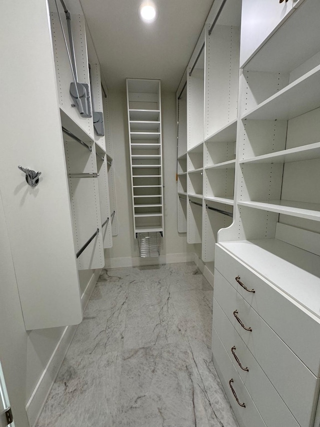 walk in closet with marble finish floor