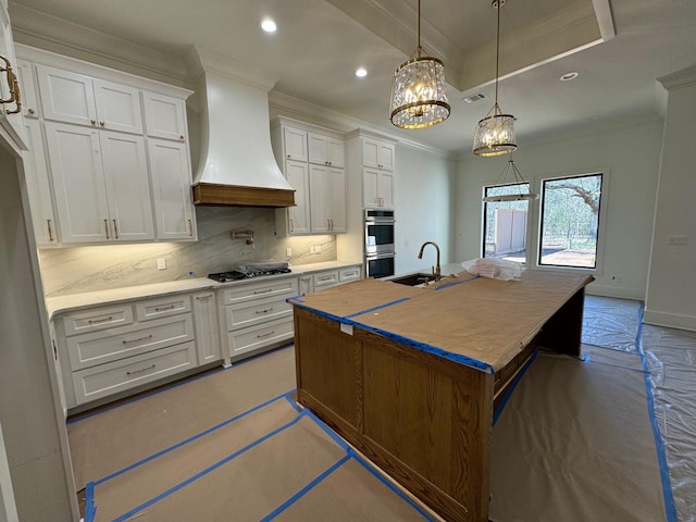 kitchen with backsplash, custom range hood, ornamental molding, appliances with stainless steel finishes, and a sink