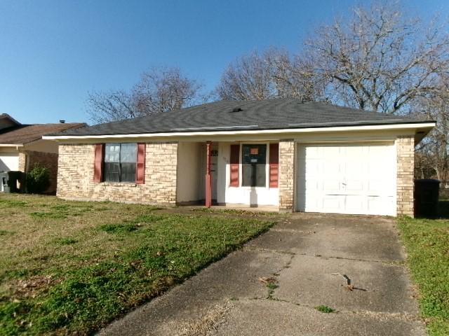 single story home with brick siding, an attached garage, concrete driveway, and a front lawn