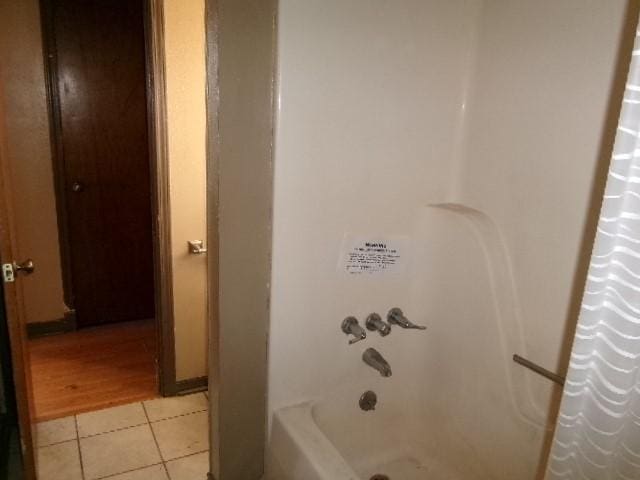 bathroom featuring tile patterned flooring and shower / tub combo with curtain