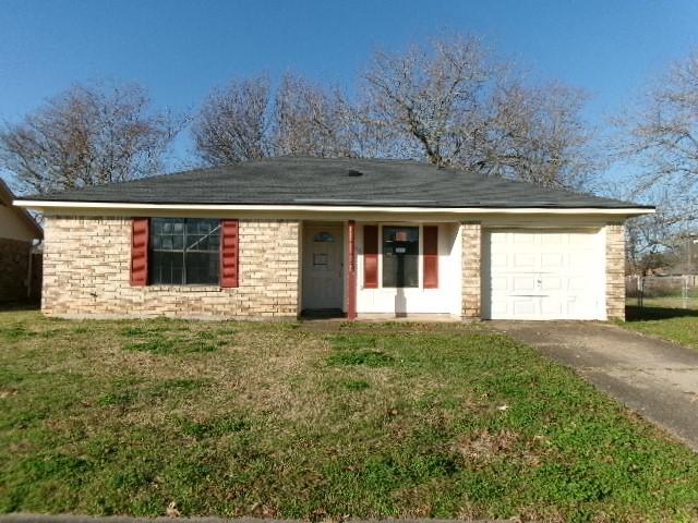 single story home featuring a front lawn, an attached garage, and driveway