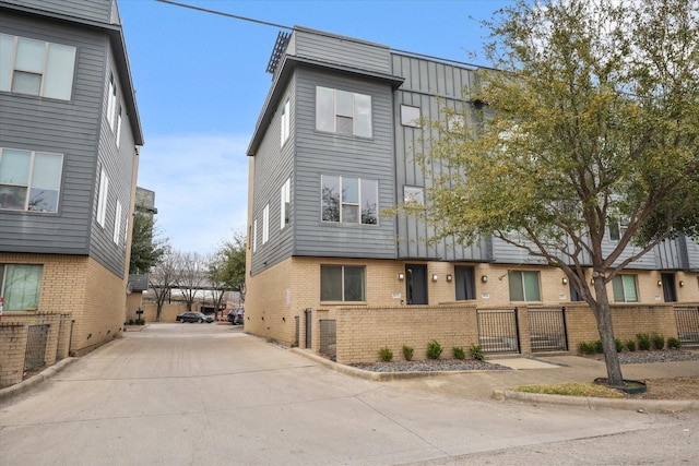 multi unit property featuring brick siding and a fenced front yard