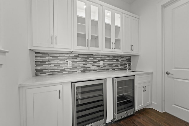 bar featuring a sink, dark wood-style floors, backsplash, and beverage cooler