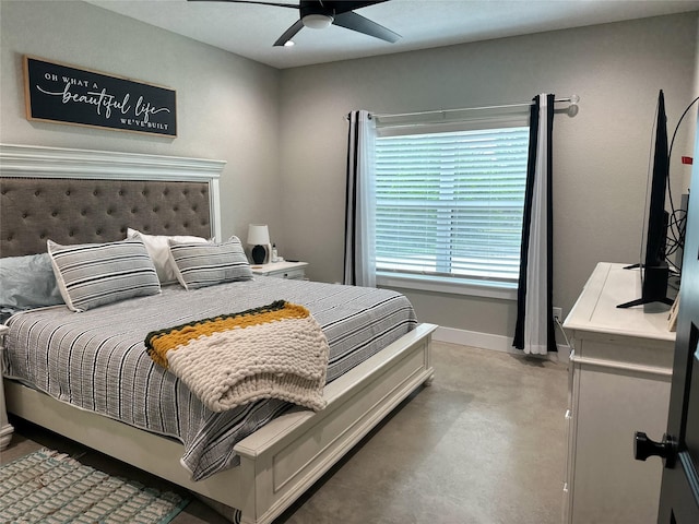 bedroom featuring a ceiling fan, concrete floors, and baseboards