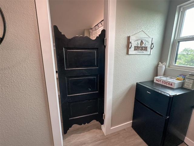 bathroom featuring wood finished floors, baseboards, and a textured wall