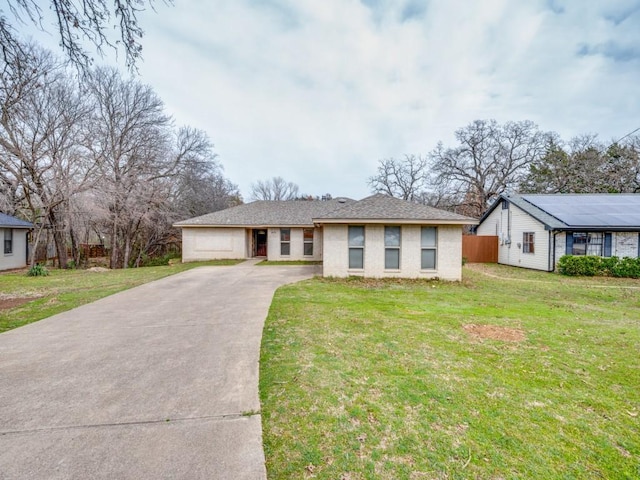 view of front of home with a front yard, fence, and driveway