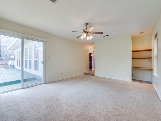 unfurnished room with ceiling fan, visible vents, baseboards, and light carpet