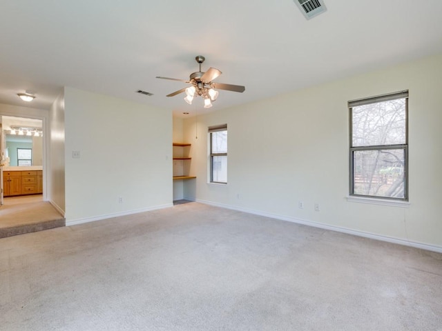 spare room featuring visible vents, baseboards, light colored carpet, and ceiling fan