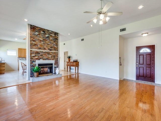 unfurnished living room with visible vents, light wood finished floors, recessed lighting, a fireplace, and ceiling fan