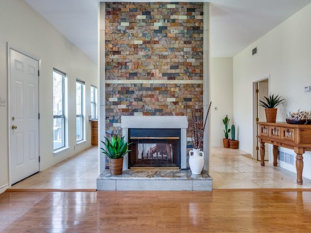 living area featuring visible vents, wood finished floors, and a fireplace