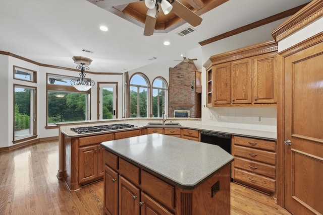 kitchen featuring a sink, brown cabinets, a healthy amount of sunlight, and stainless steel gas stovetop