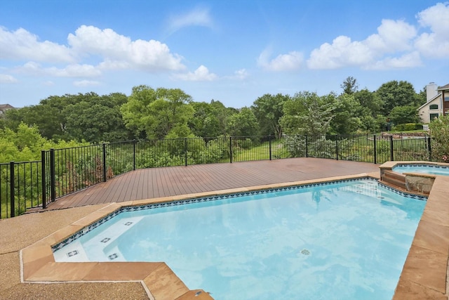 view of swimming pool featuring a pool with connected hot tub and a wooden deck