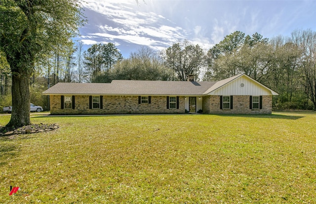 ranch-style home featuring brick siding, a chimney, and a front lawn