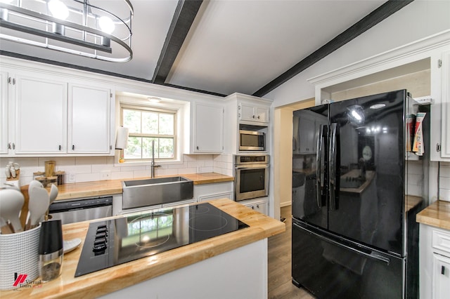 504 Mockingbird Ln, Logansport, LA 71049 - kitchen with black appliances, lofted ceiling with beams, wooden counters, and a sink