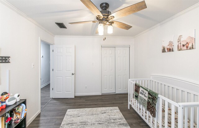 504 Mockingbird Ln, Logansport, LA 71049 - bedroom featuring visible vents, dark wood-type flooring, ornamental molding, a closet, and baseboards