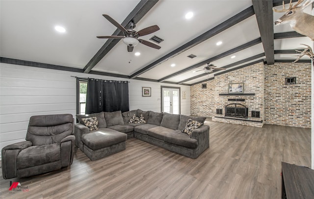 504 Mockingbird Ln, Logansport, LA 71049 - living area featuring lofted ceiling with beams, visible vents, wood finished floors, and a fireplace