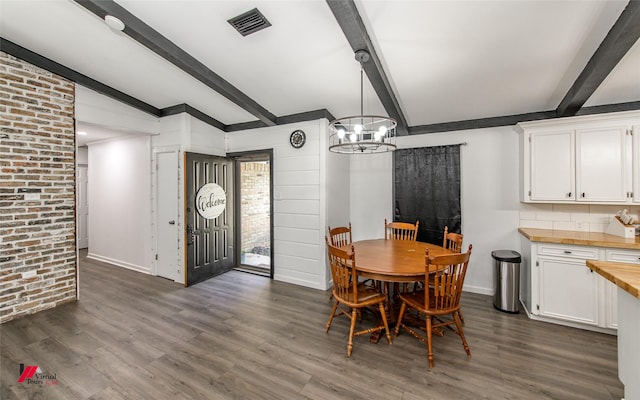 504 Mockingbird Ln, Logansport, LA 71049 - dining space with dark wood-style floors, visible vents, brick wall, baseboards, and an inviting chandelier