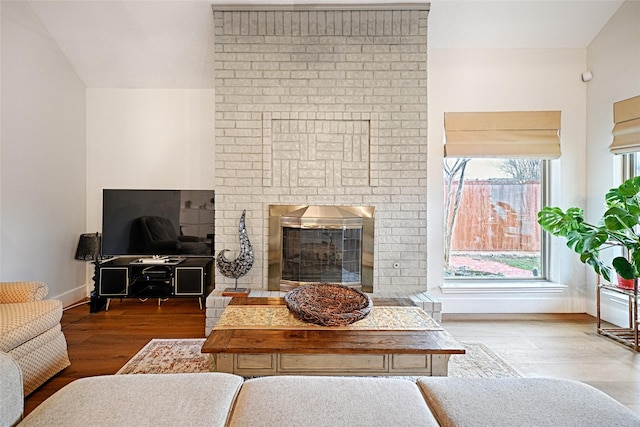 living room with a fireplace, wood finished floors, and baseboards